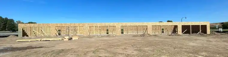 A framed building on a bare lot.