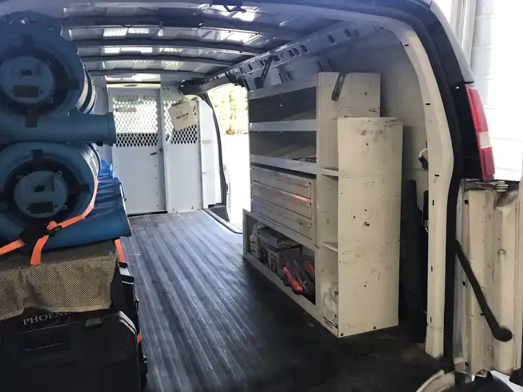 Inside our work van: shelving and stacked air movers, loaded and ready.