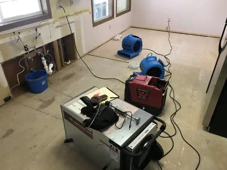 Drying equipment set up in a gutted kitchen.