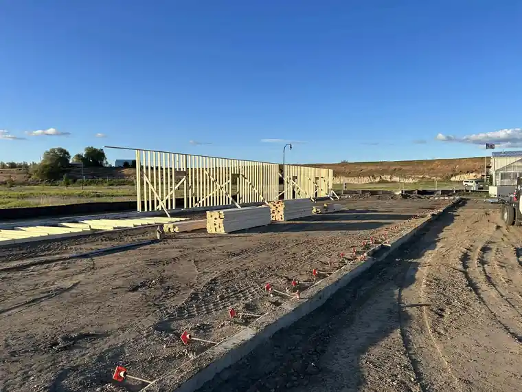 New stud walls standing on a fresh slab at sunset on a CRC construction site